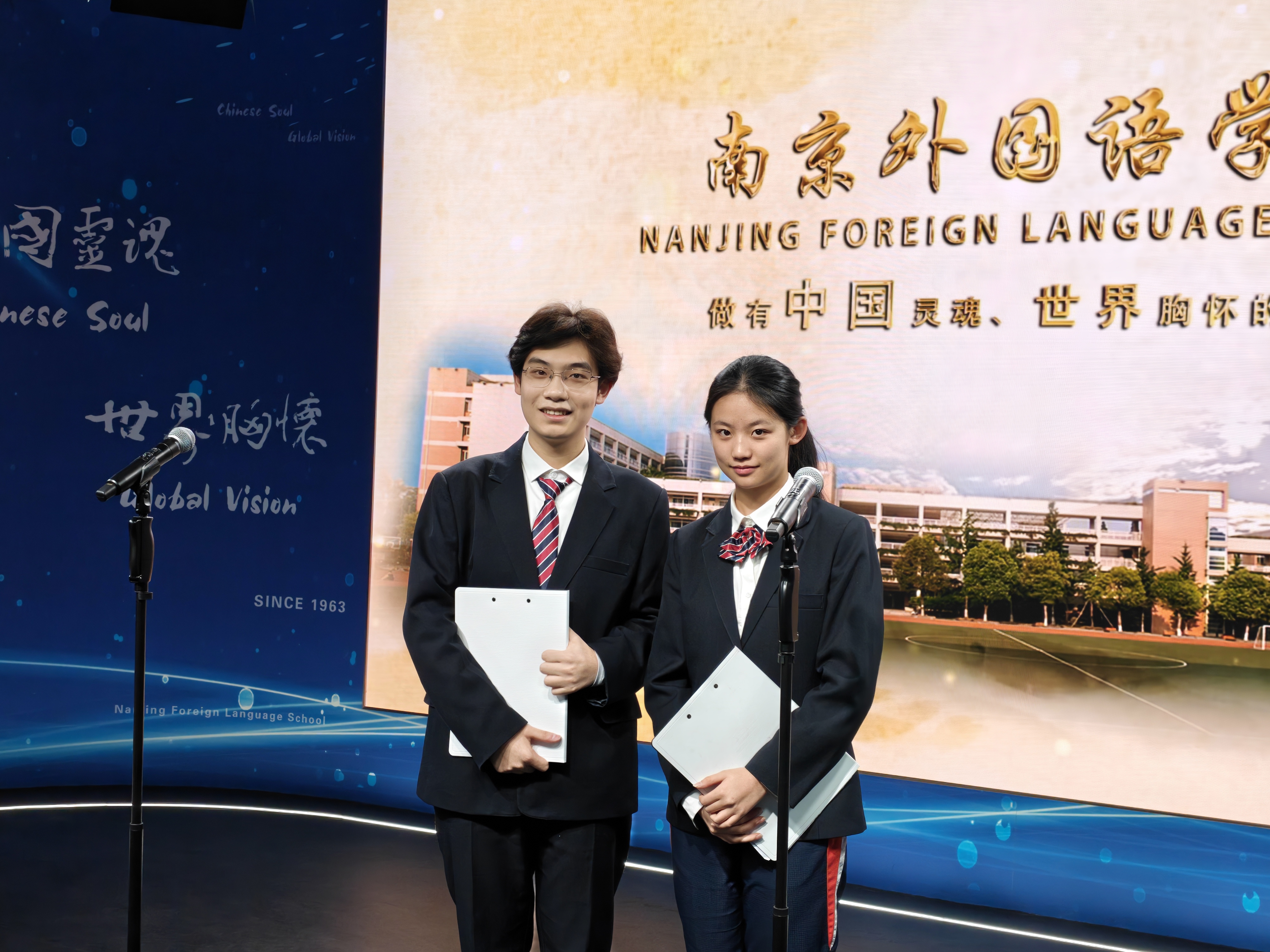 Two student presenters speaking on stage