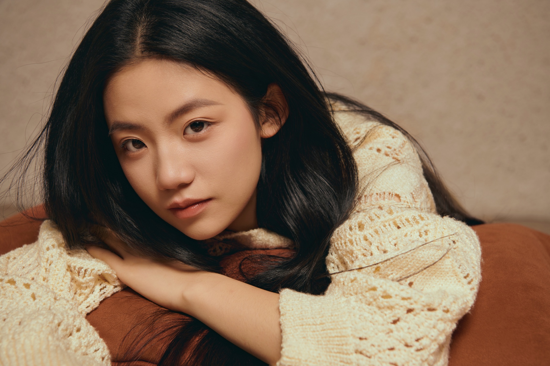 Ziyue in a cream sweater, photographed in warm natural light
