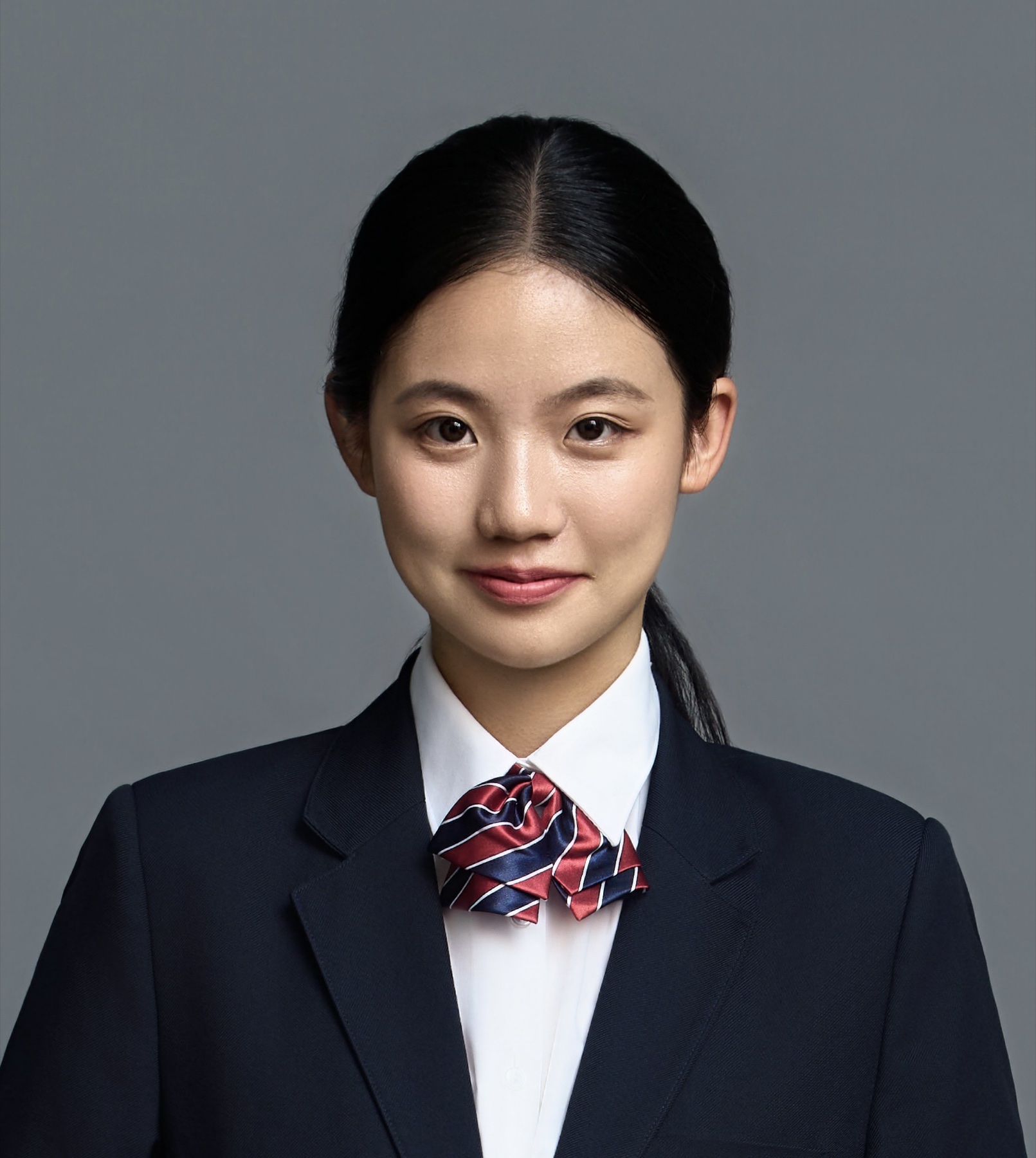 Ziyue Li in school uniform against a gray studio background