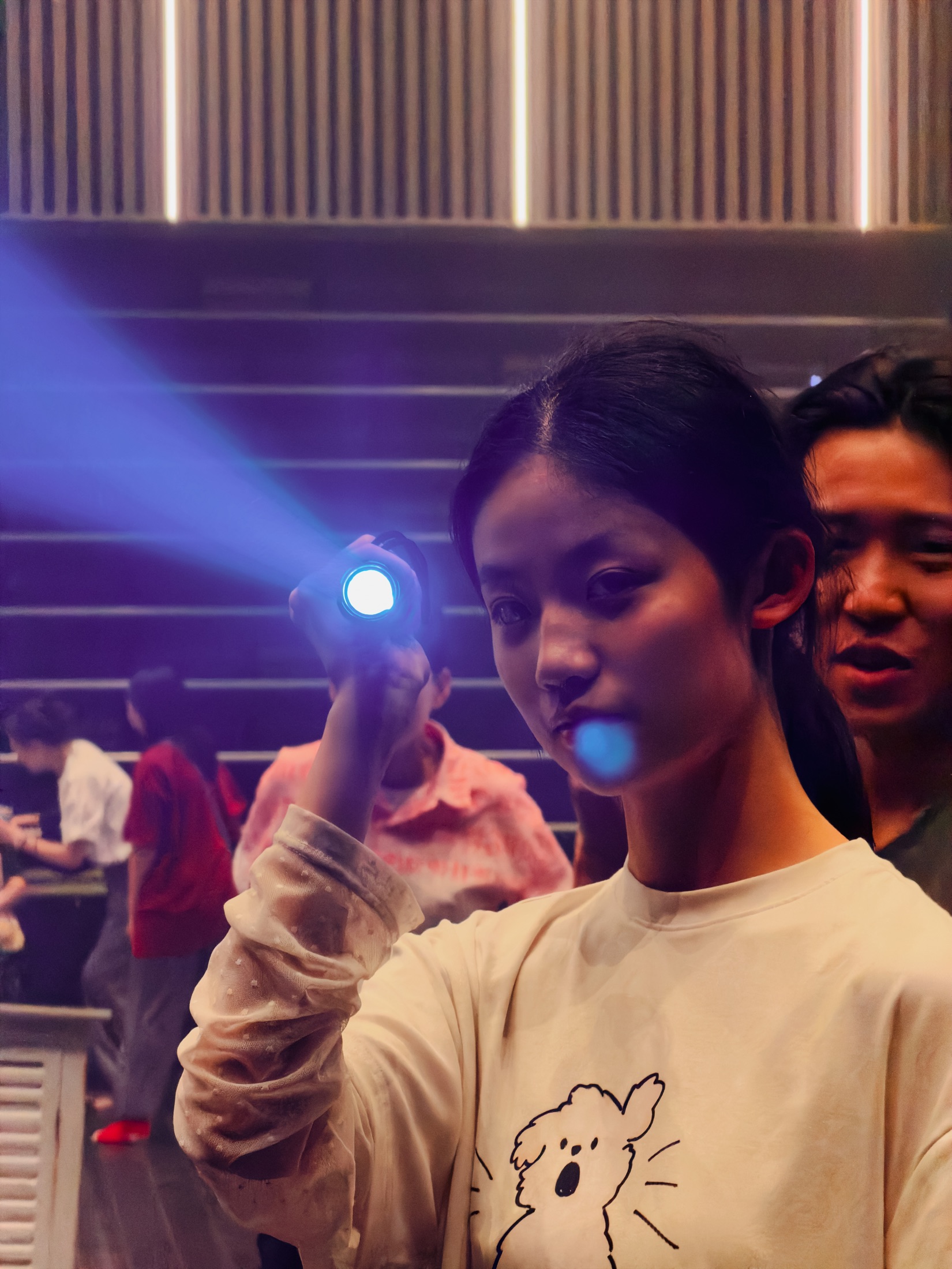 Ziyue holding a light during a physical theatre rehearsal